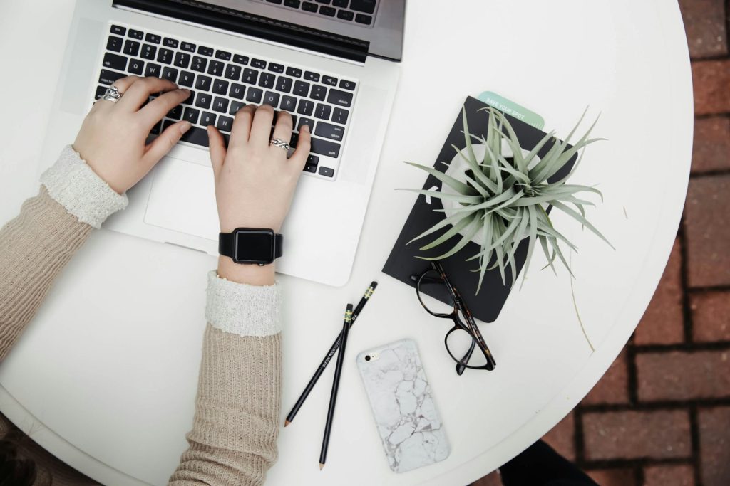 persona usando una computadora portátil junto a una planta de aloe vera